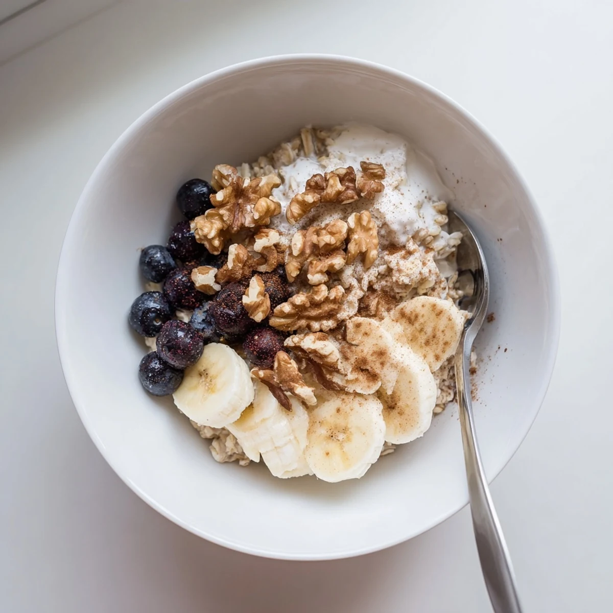Mason jar of wholesome brown sugar overnight oats layered with cinnamon, Greek yogurt, and vibrant mixed berries