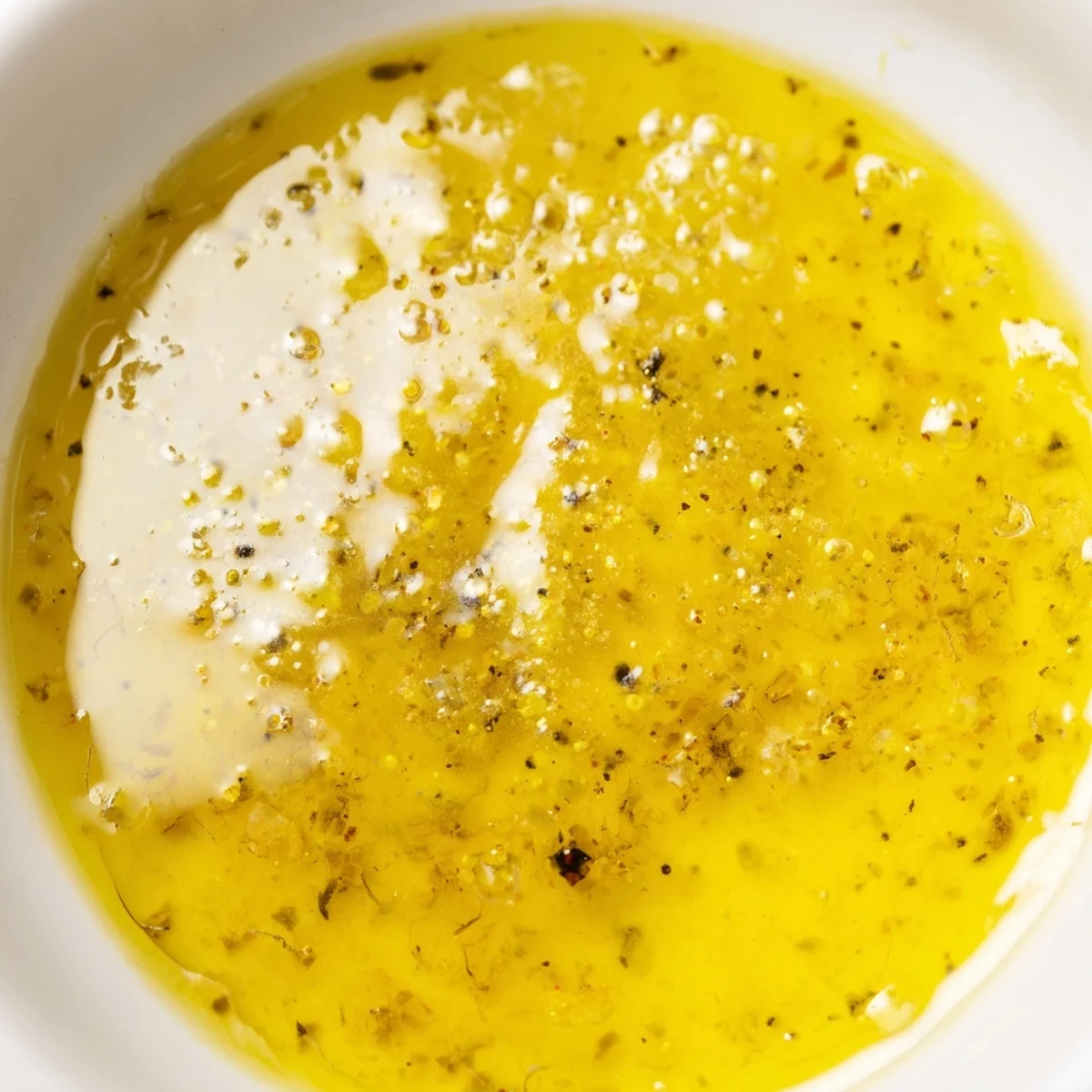 Glass mason jar filled with creamy emulsified easy lemon vinaigrette dressing ready for refrigeration storage