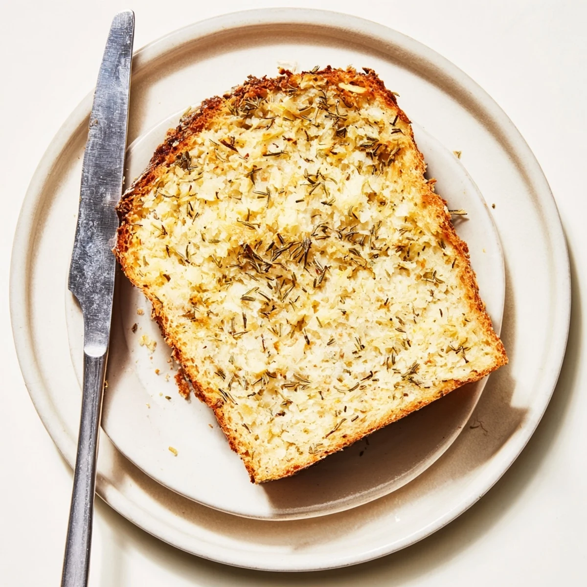 Freshly baked Parmesan herb keto bread with crispy golden crust and aromatic herb topping close-up