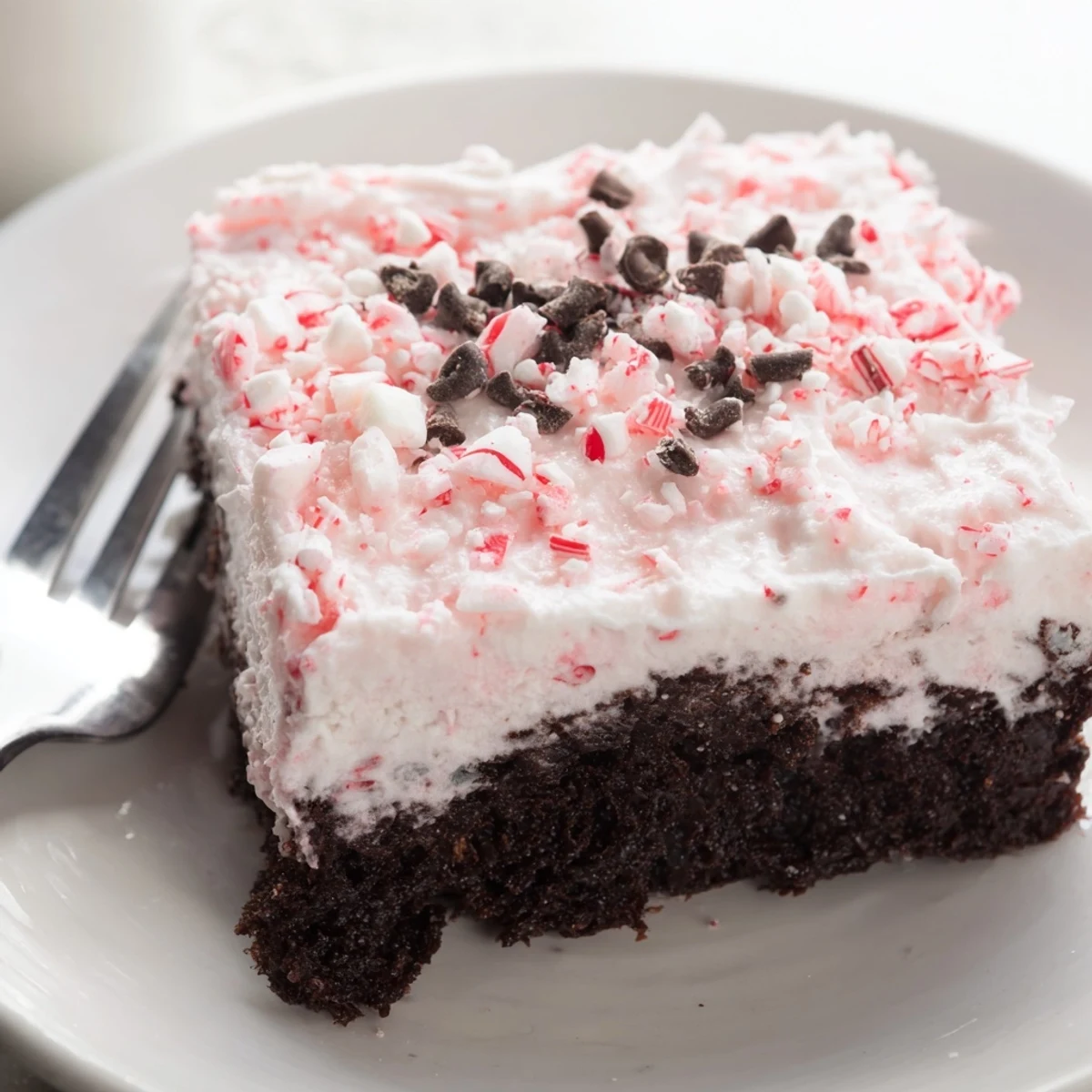 Sliced Peppermint Poke Cake revealing minty pudding soaked into moist chocolate.