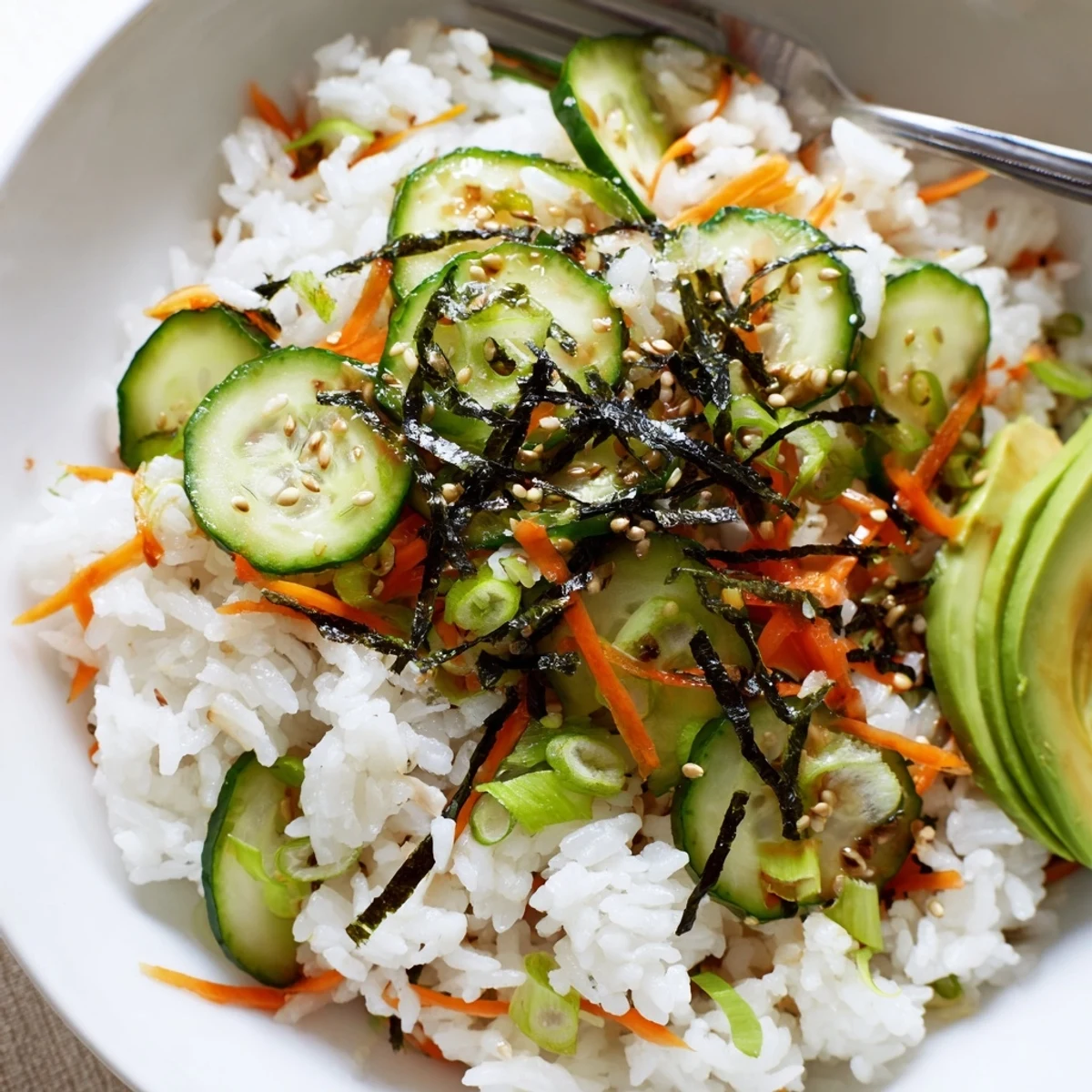 Chilled Sushi Cucumber Salad served in bowls, avocado slices and pickled ginger