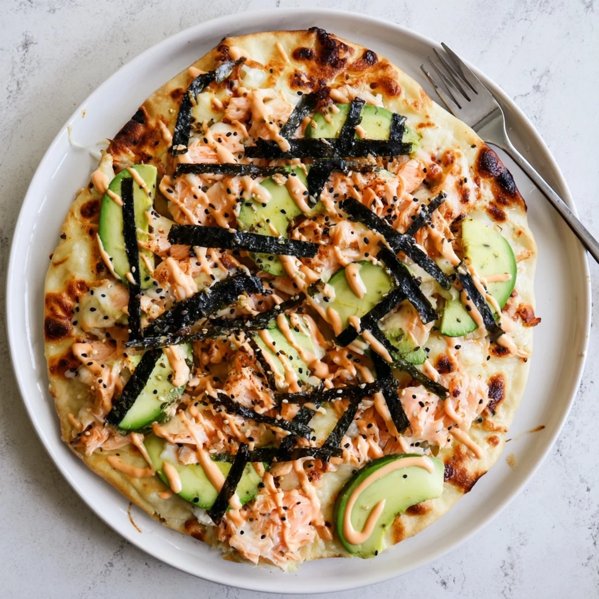Crispy flatbread loaded with creamy salmon rice mixture melted mozzarella and vibrant cucumber avocado toppings