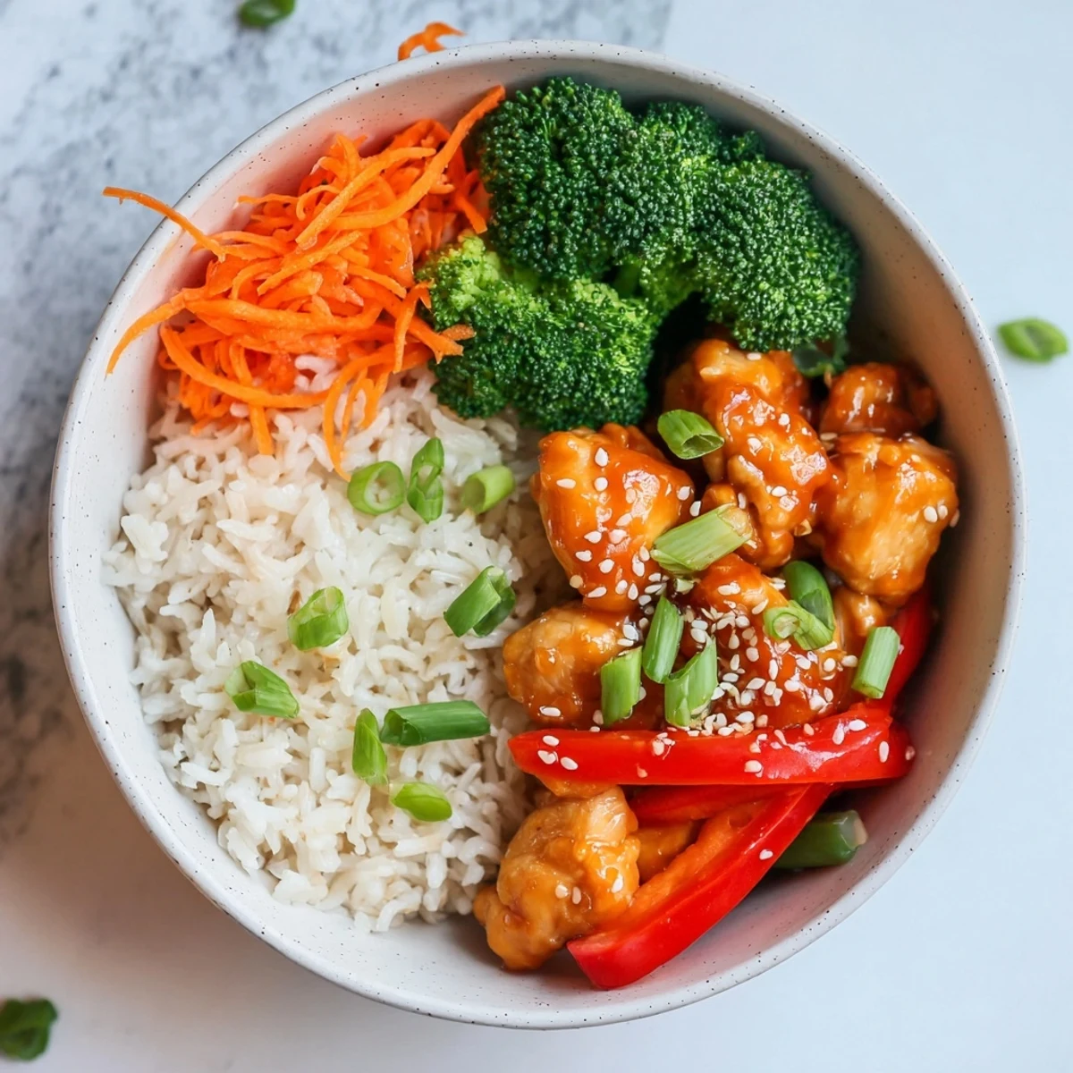 Asian-style orange glazed chicken bowl with steamed vegetables and glossy sweet tangy sauce coating