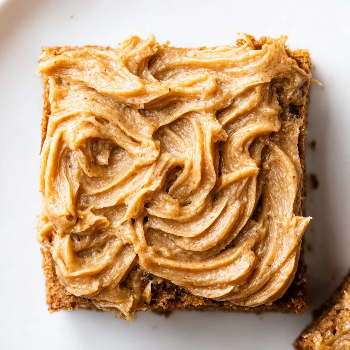 Moist banana bread brownies with swirls of rich brown butter frosting, cut into generous squares