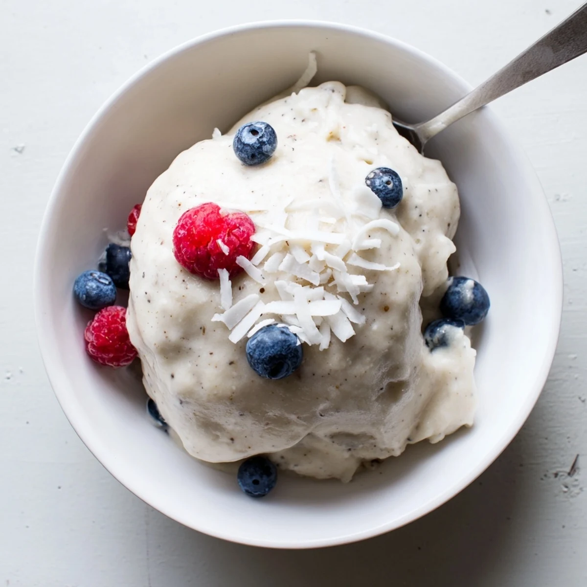 Vibrant pink healthy nice cream swirled into a serving bowl with dark chocolate chips scattered on top.