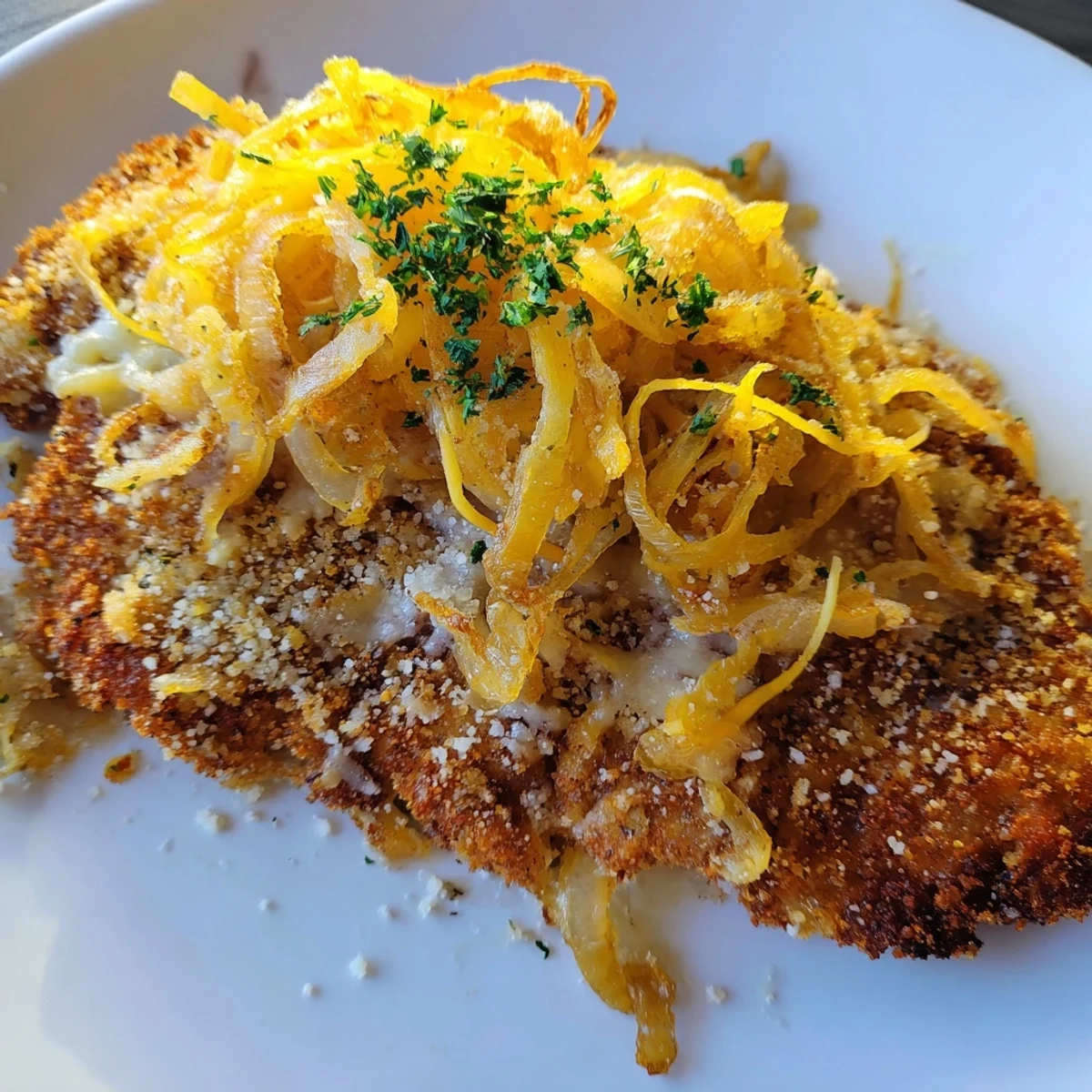 Crispy Chicken Caramelized Onions Melted Cheese bubbling, served with roasted vegetables.