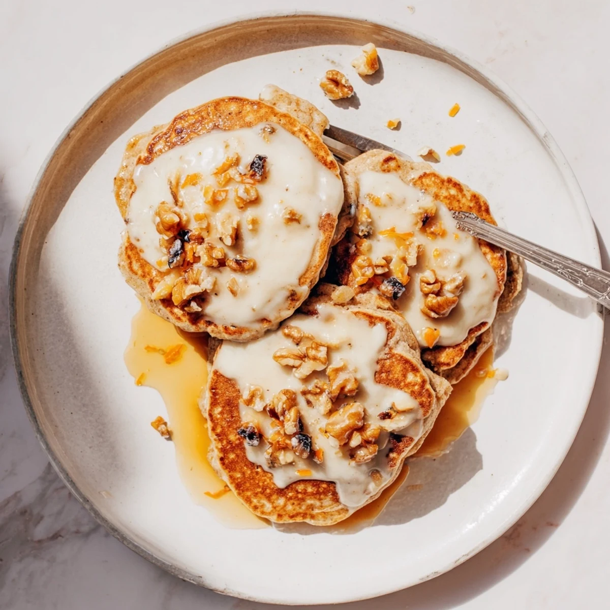 Fluffy carrot cake pancakes topped with walnuts and drizzled with sweet maple syrup
