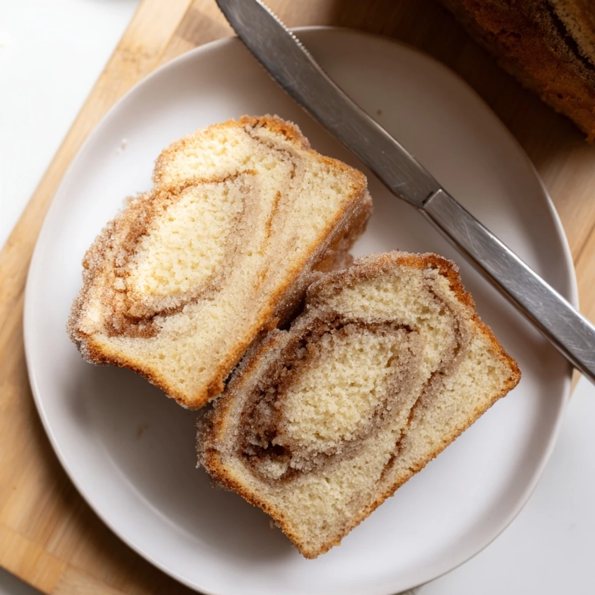 Warm cinnamon donut loaf sliced thick with a golden cinnamon sugar crust