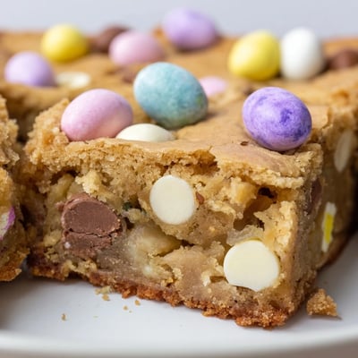 Chewy Mini Cadbury Easter Egg blondies cut into squares showing gooey chocolate-studded interior